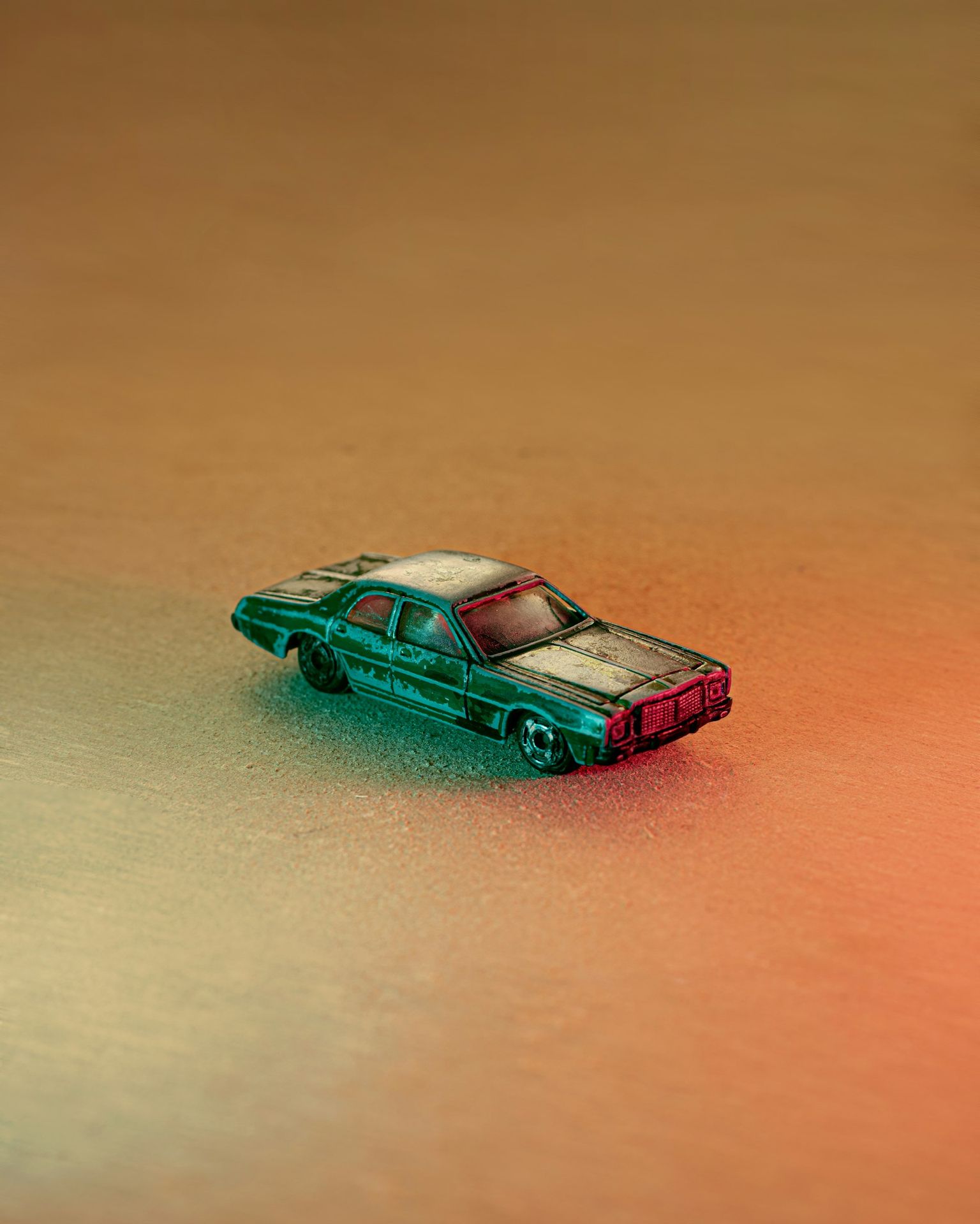 teal car scale model on brown wooden table